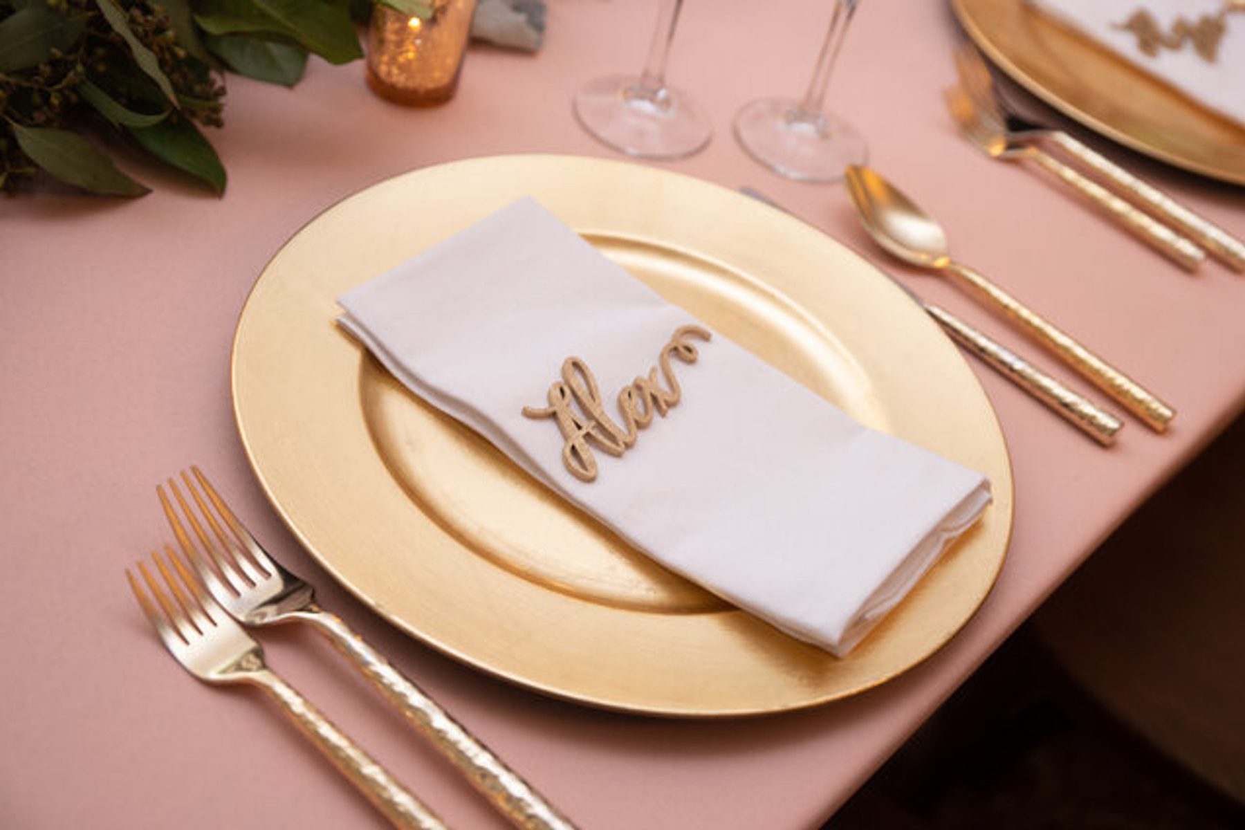 A blush place setting with menu card and napkin
