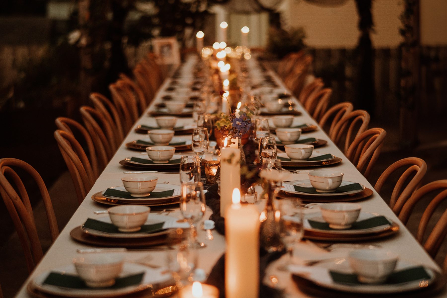 A long banquet table lit end to end with candles