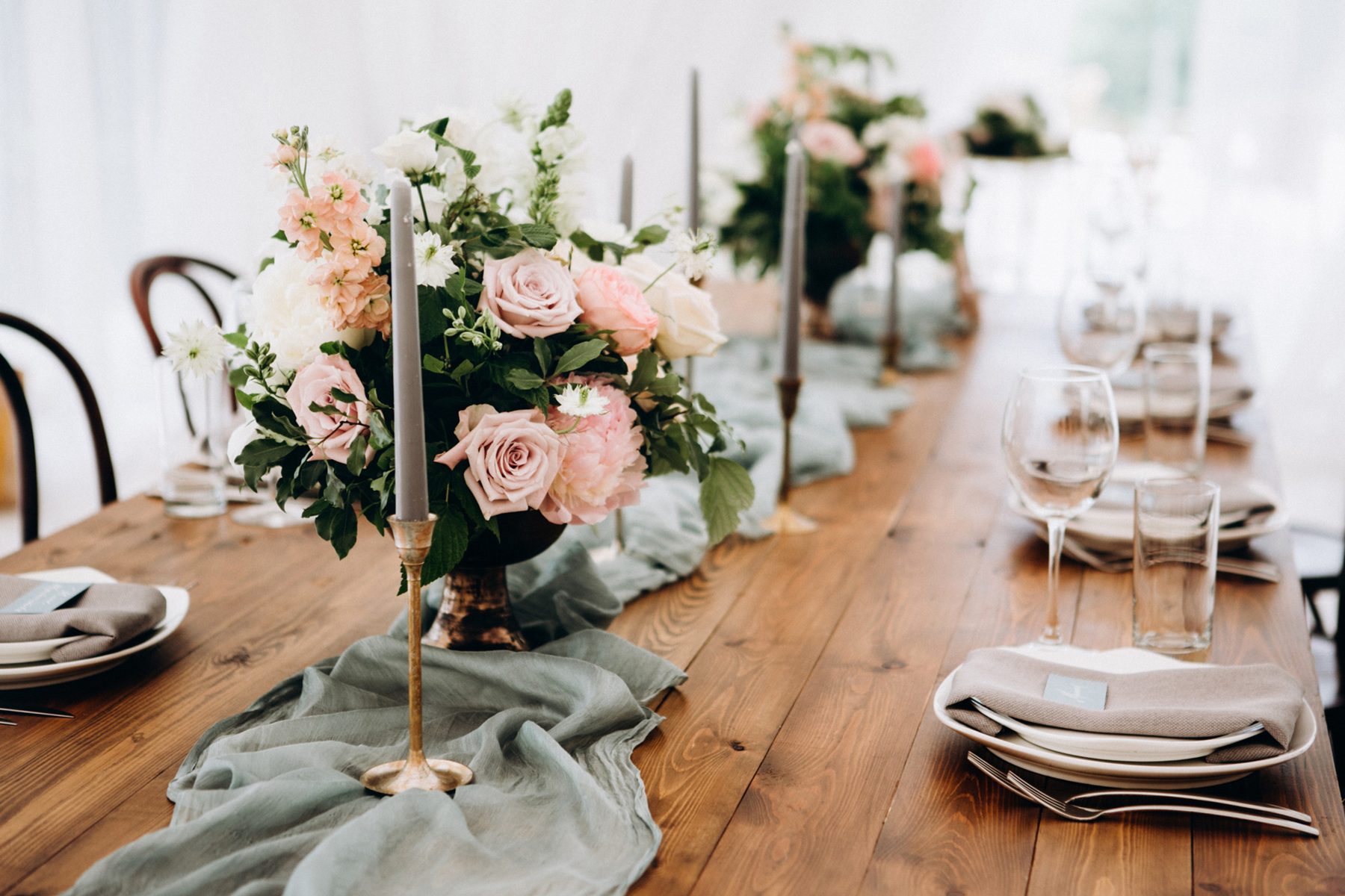A sage linen table setting with layered glassware
