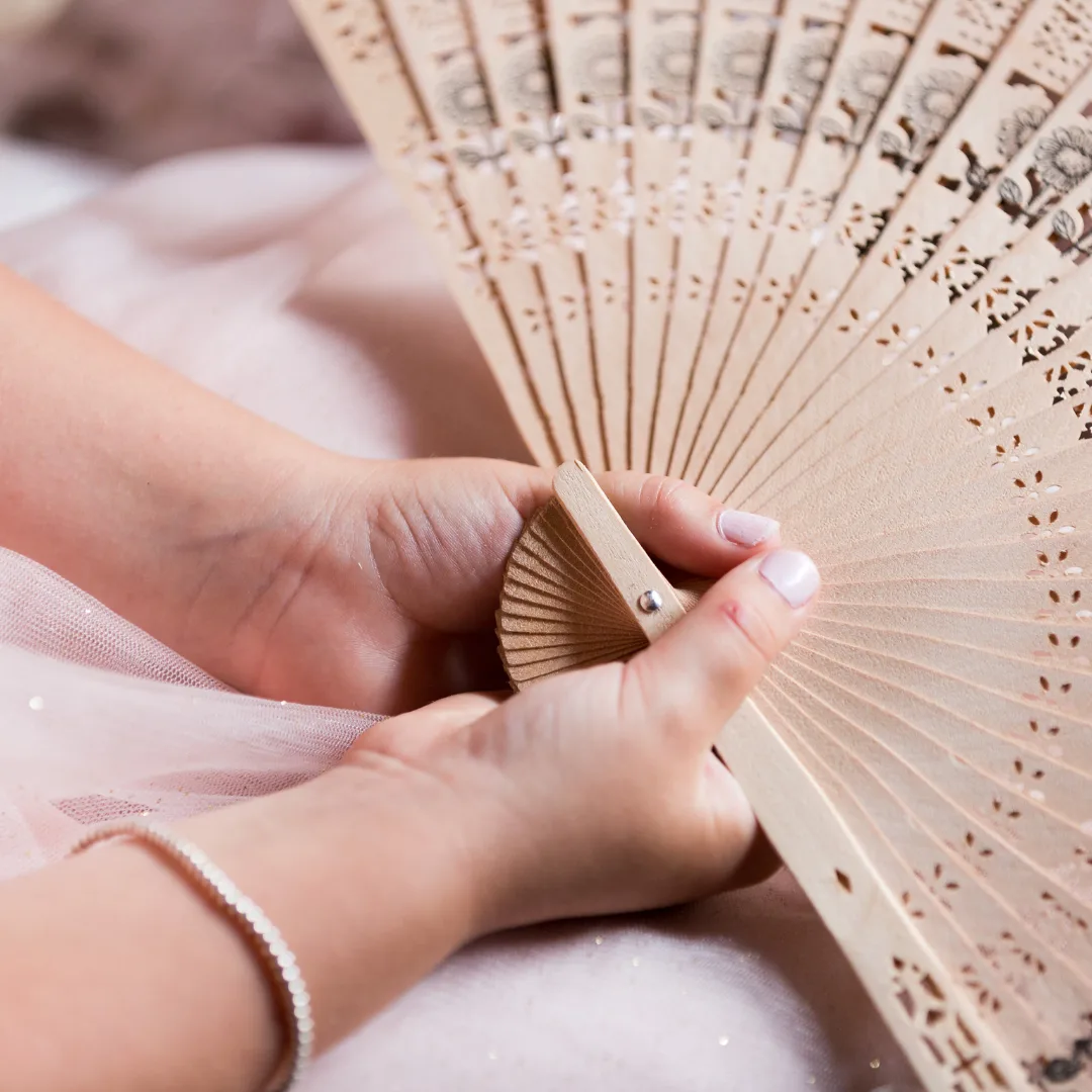 girl holding wood hand held fan