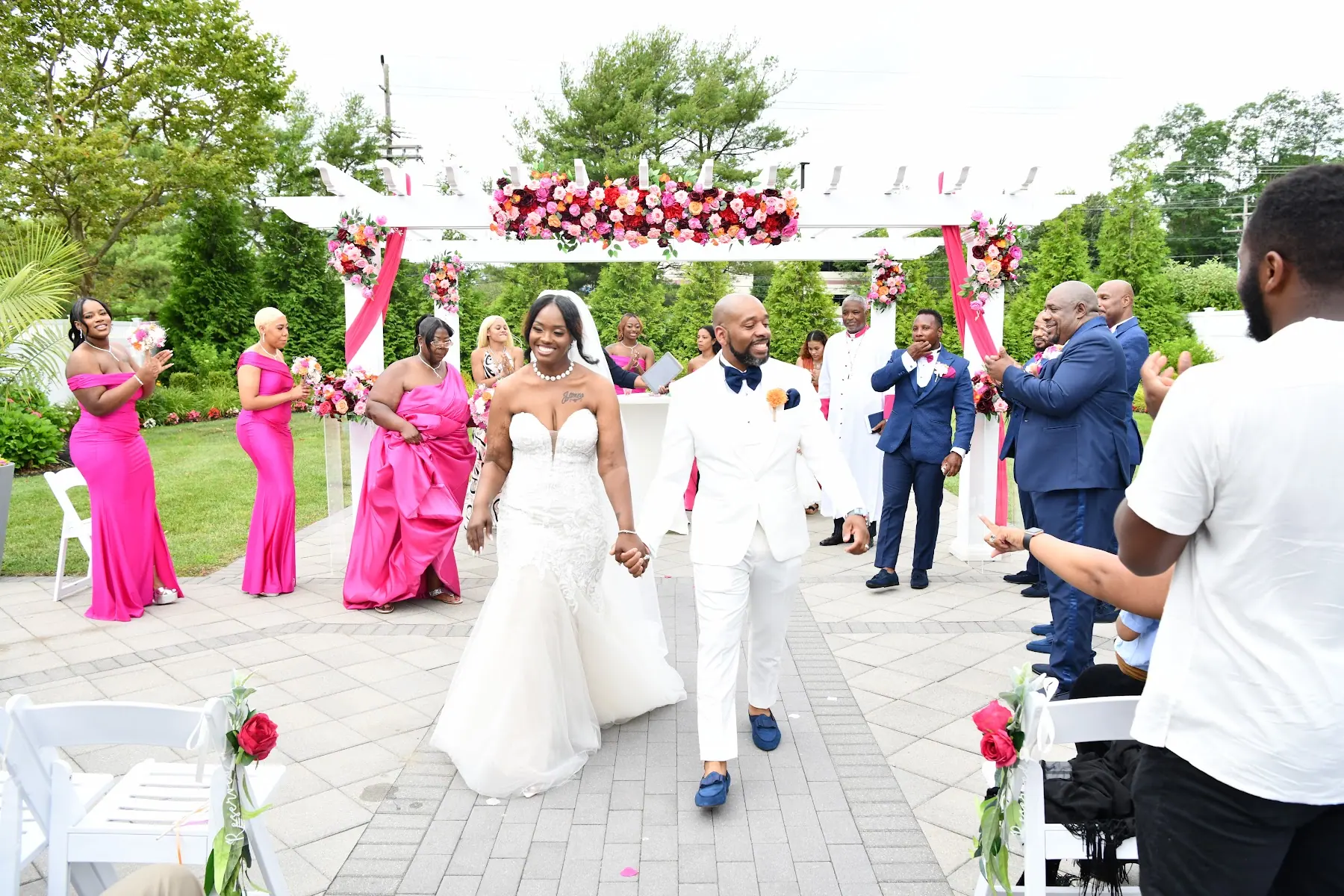 The newlyweds walking back down the garden aisle